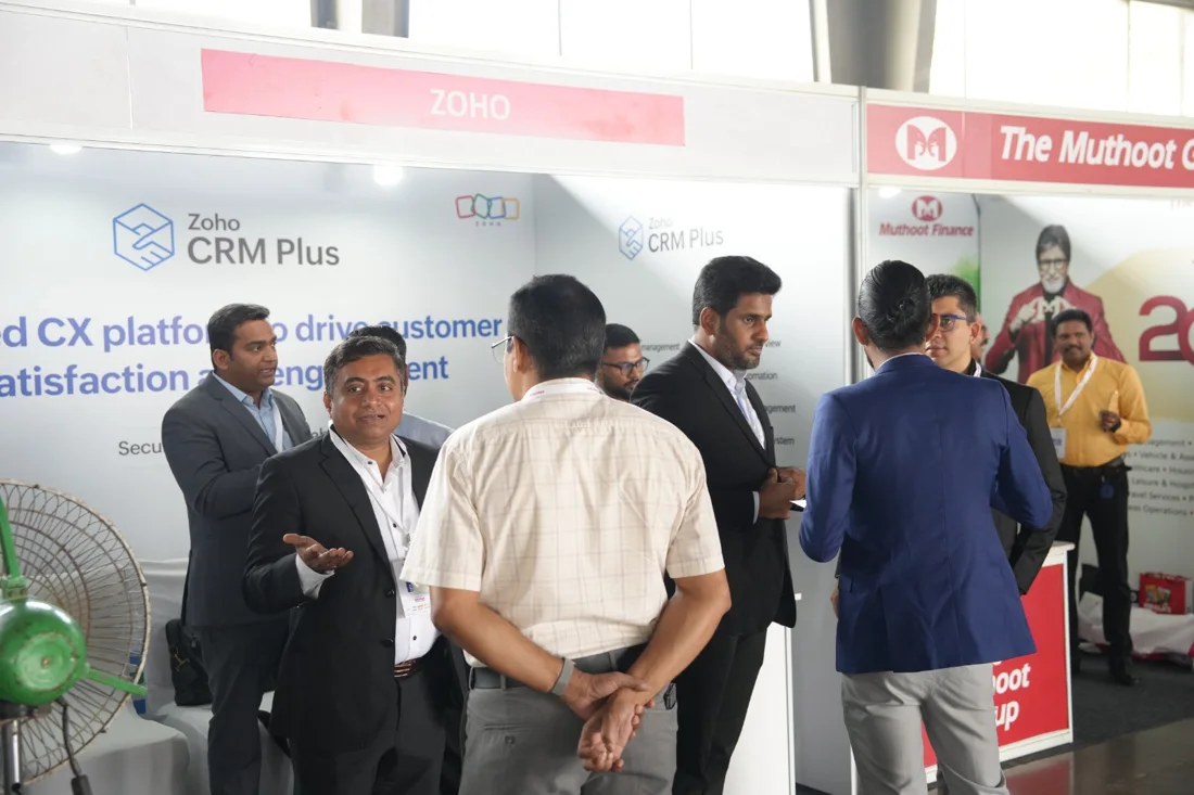Delegates speaking with exhibition partners at a Dhanam event